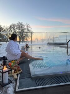 Ångande utomhuspool på Hotel Skansen med kvällsljus och harmonisk utsikt.