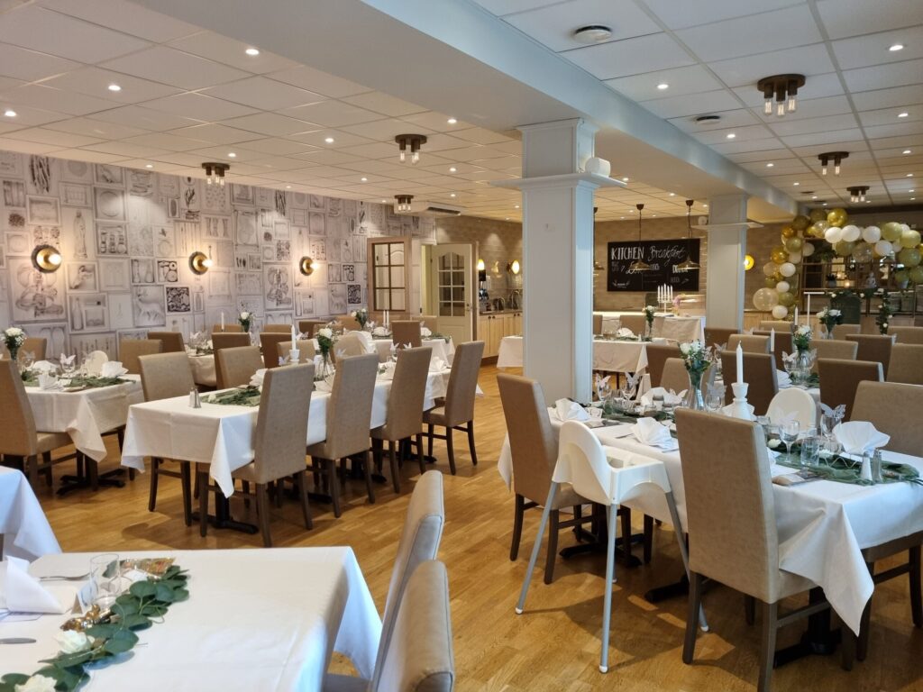 En ljus och inbjudande festlokal med vita dukar, gröna inslag och ballongdekoration på Hotel Skansen.