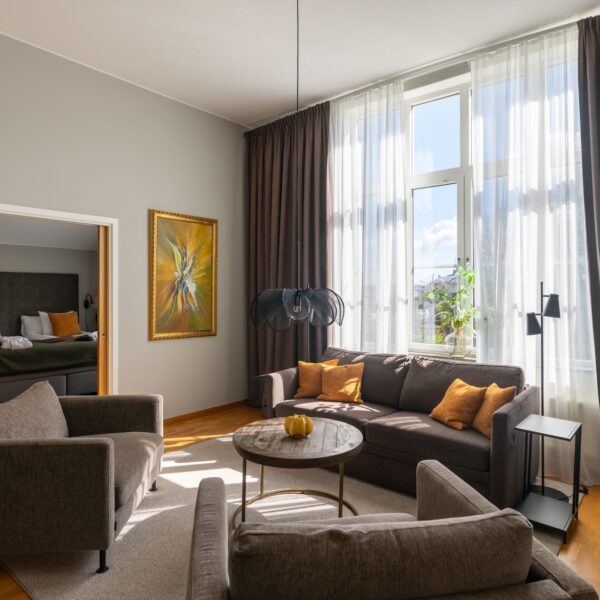 På bildens syns sviten hos Hotel Skansen på Öland. Rummet består av två rum, ett vardagsrum med soffgrupp och matplats samt en sovrum med dubbelsäng och skrivbord.
