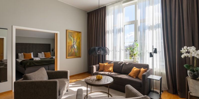 På bildens syns sviten hos Hotel Skansen på Öland. Rummet består av två rum, ett vardagsrum med soffgrupp och matplats samt en sovrum med dubbelsäng och skrivbord.