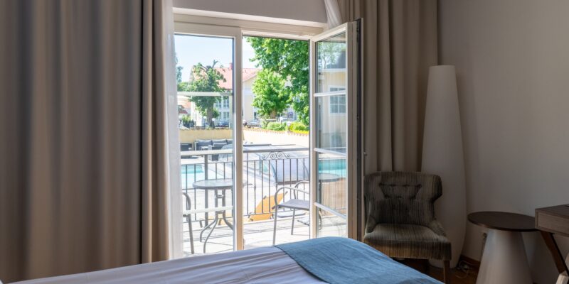 På bildens syns ett standardrum med uteplats hos Hotel Skansen på Öland. Rummet har en öppnad dörr som leder ut till en uteplats.
