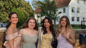 4 tjejer glada tjejer som tittar in i kameran i sina balklänningar på Hotel Skansen Öland under sin examensbal. 