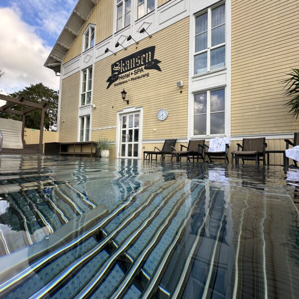Utomhuspoolen på Hotel Skansen Öland. I abkgrunden ser man Tingshuset med Skansens logga på.